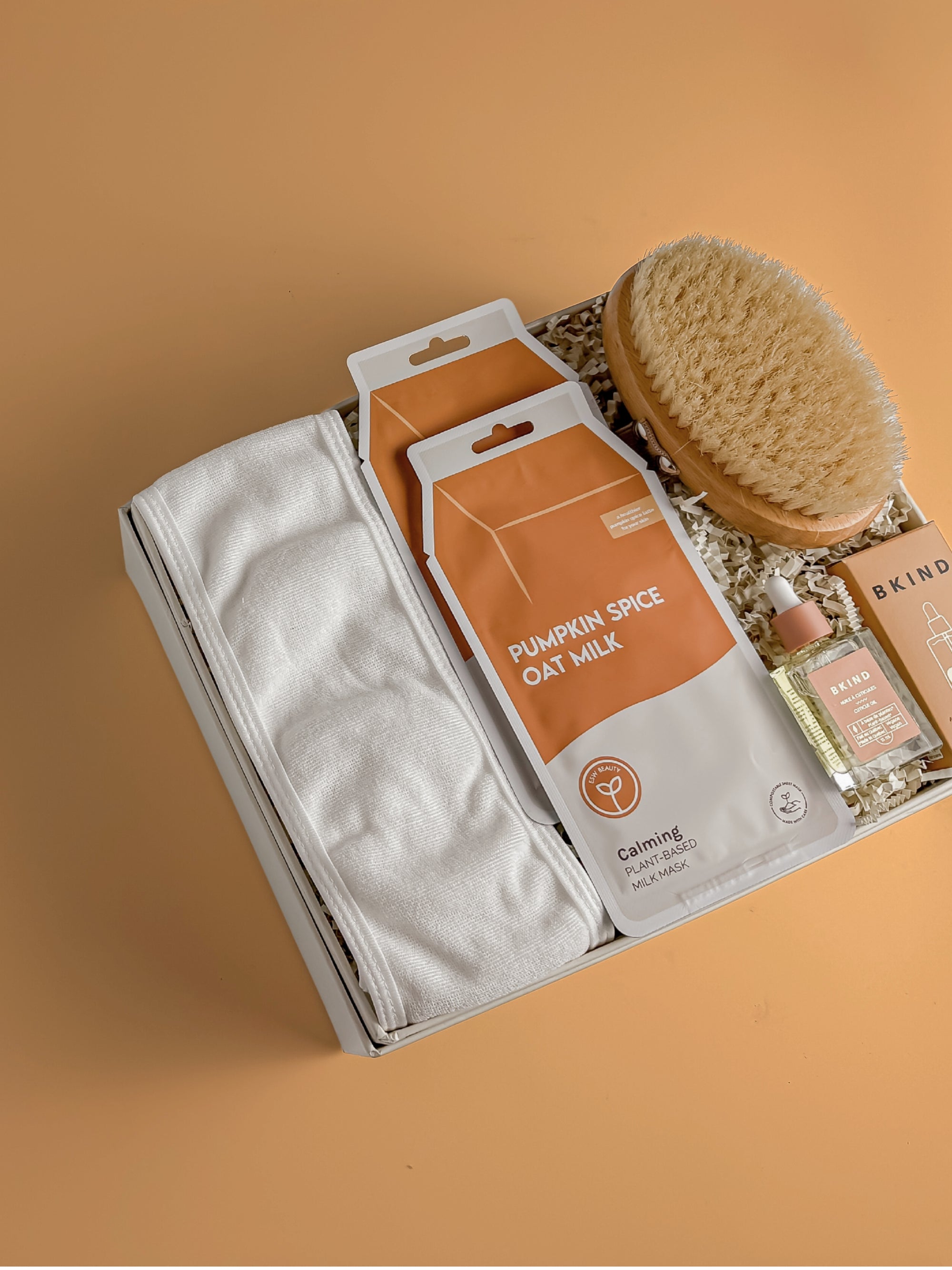 Fall Gift Boxes, Pumpkin Spice Gift Box, Corporate Gift Boxes, Skincare product set with face mask, scrub, and brush on a beige background